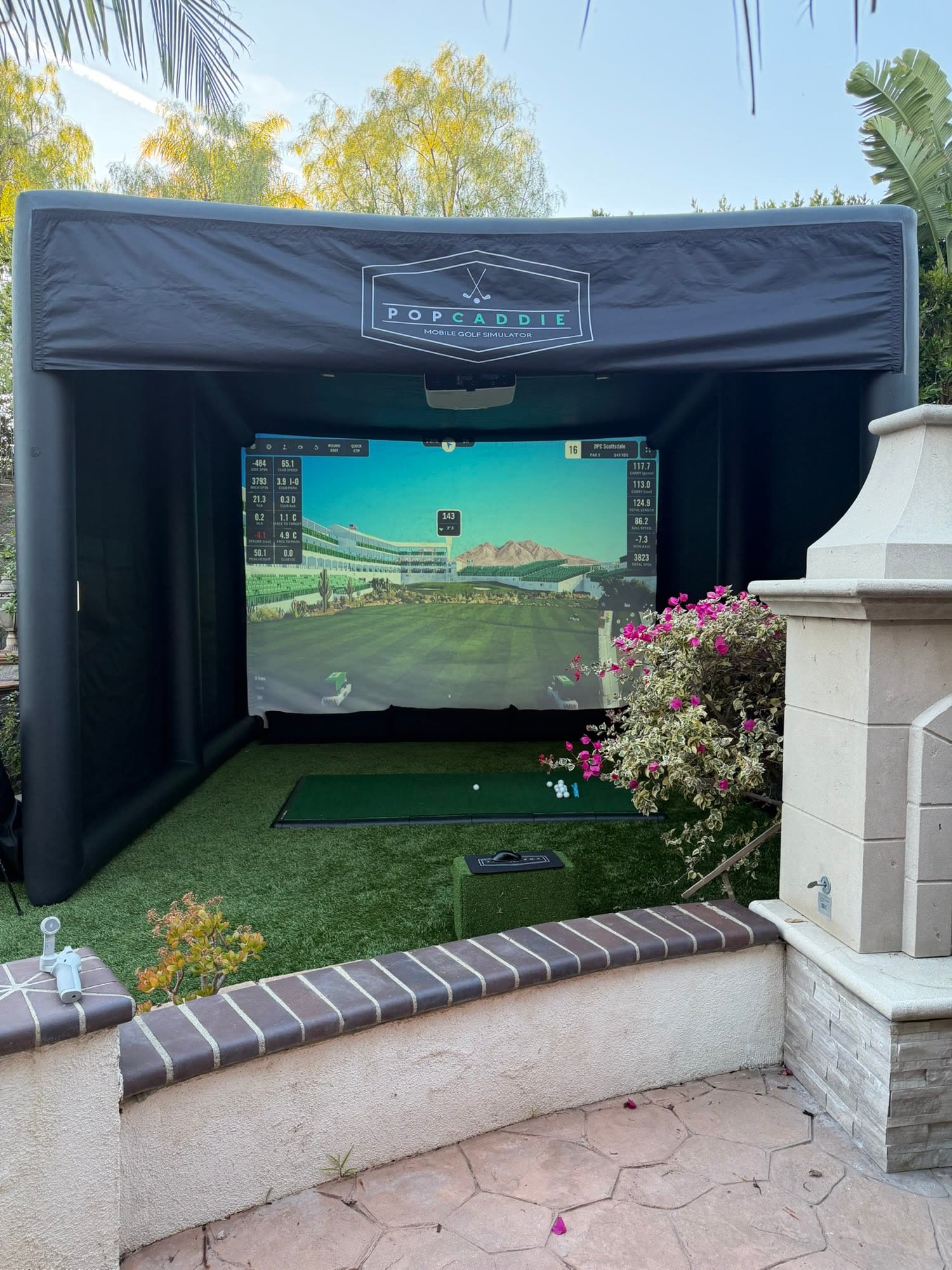 Inflatable golf simulator set up in a house garden (PopCaddie event)
