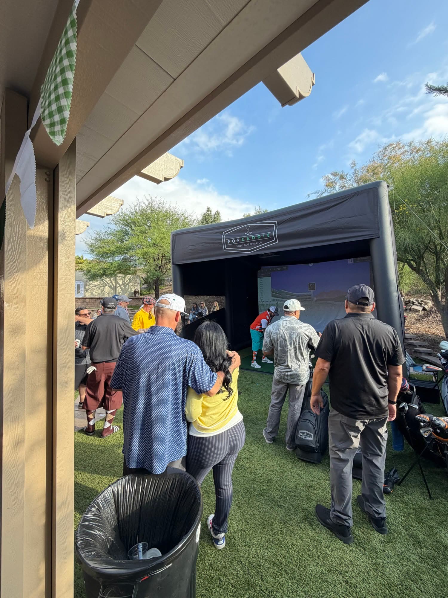Crowd around the golf simulator at an outdoor event (PopCaddie event)